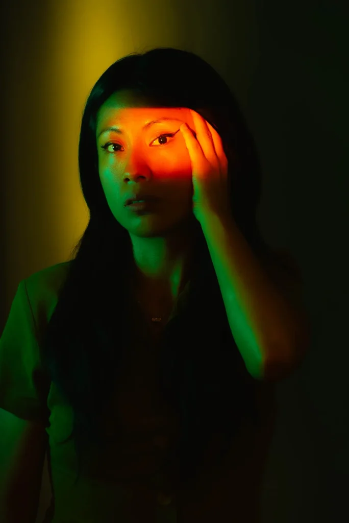 A hand on the forehead, against yellow