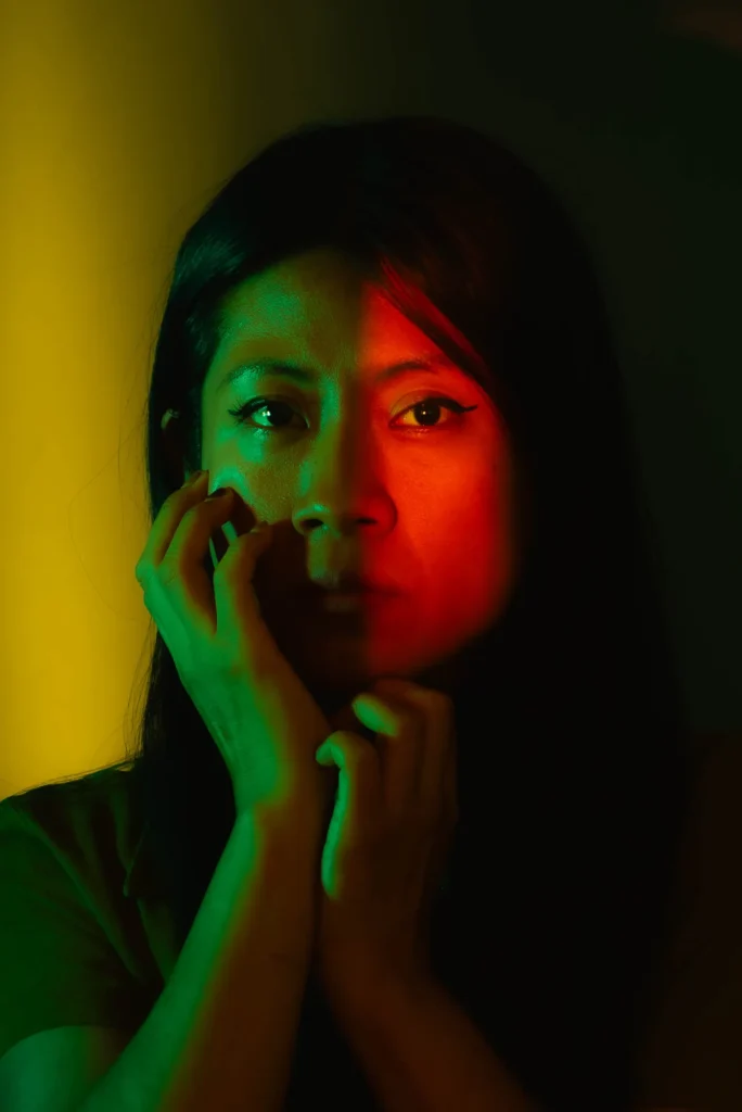 Hand at her cheek, half her face in red