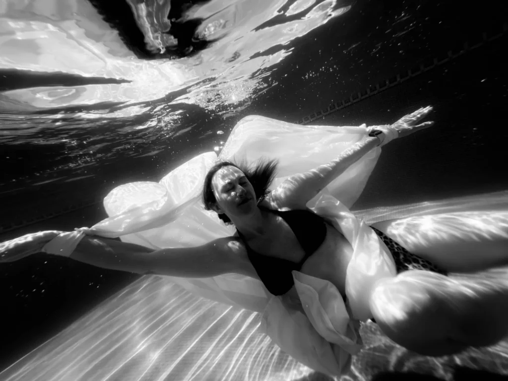 Lying on the water among white folds