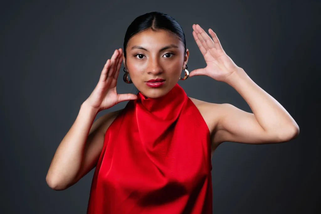 Red satin, her hands framing her face
