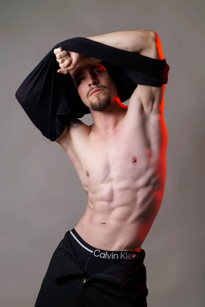 Pulling his shirt over his head