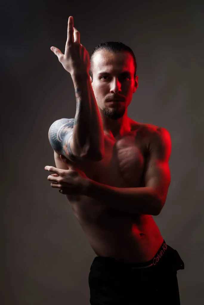 One arm reaching up, the other across