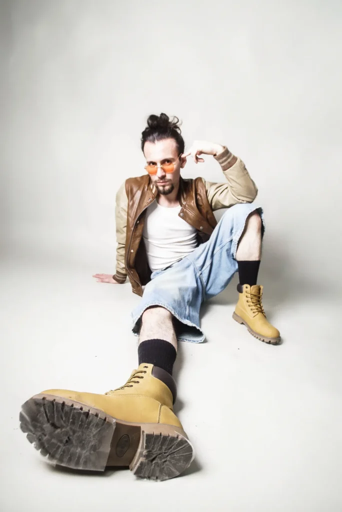 Seated on the floor, a boot toward the lens