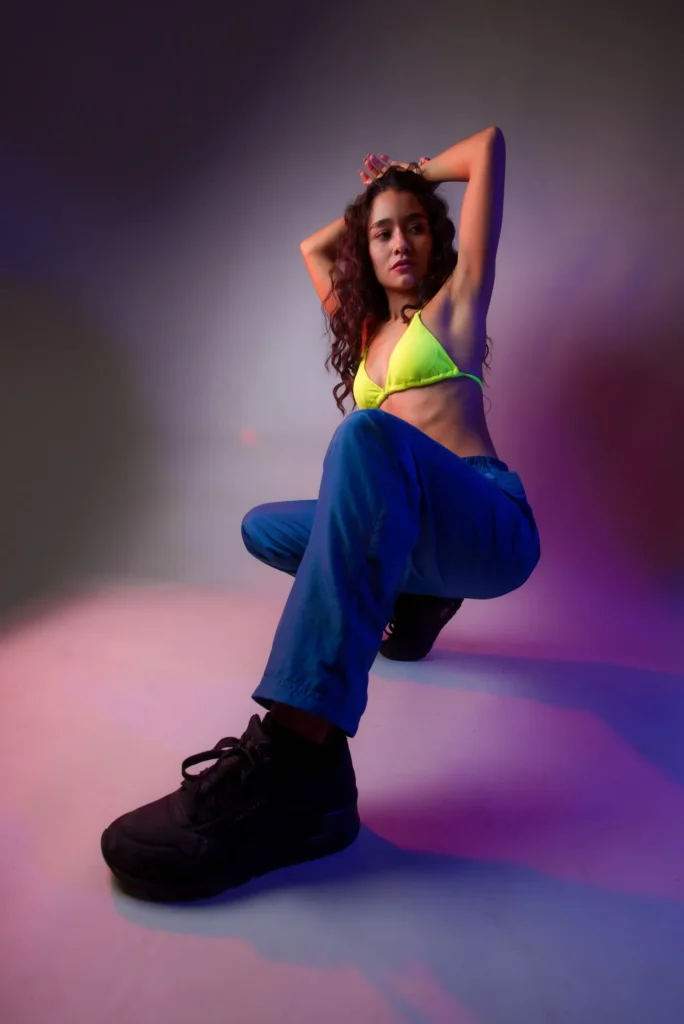 Kneeling, arms overhead, in pastel light