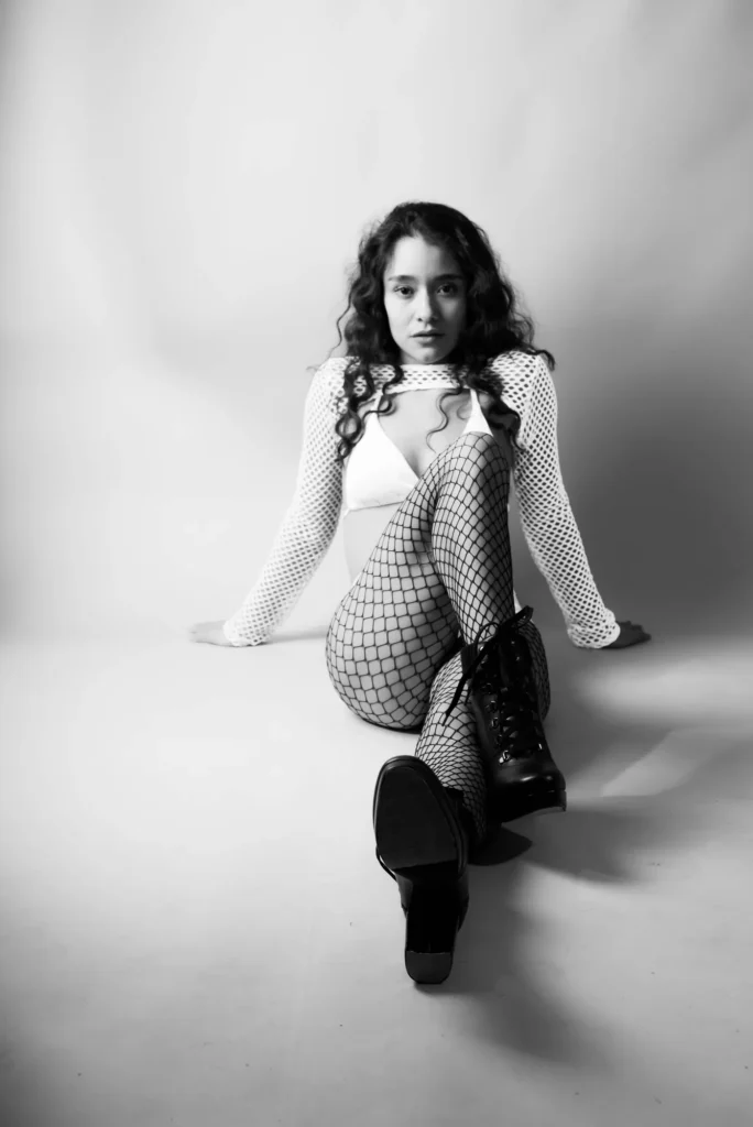 Seated on the floor, in black and white