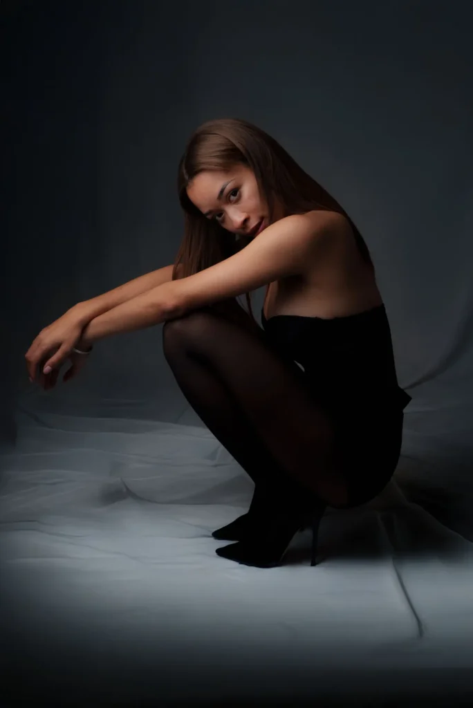 Crouched in black, chin on her arms