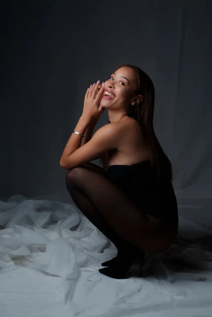 Crouched on white fabric, laughing