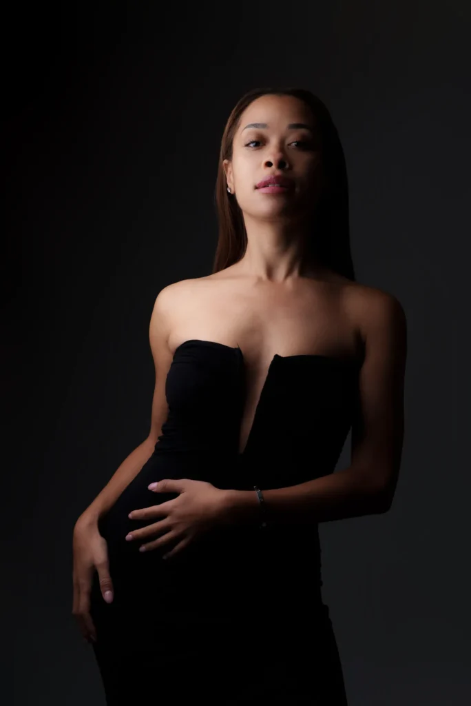 A strapless black dress in low light