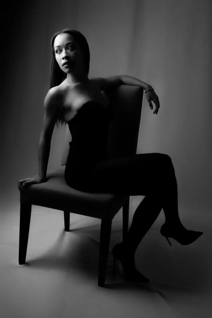 Sideways on a chair, in black and white