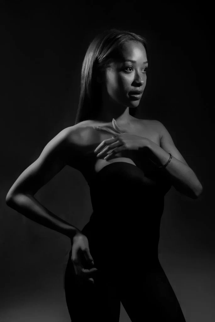 A hand at her chest, in black and white