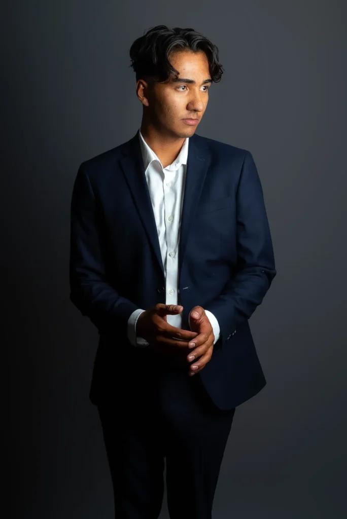 A navy suit, looking aside