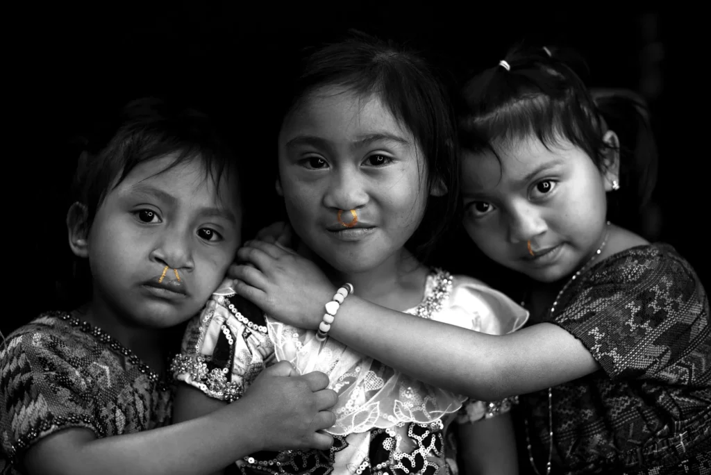 Three children embracing; each scar traced in gold