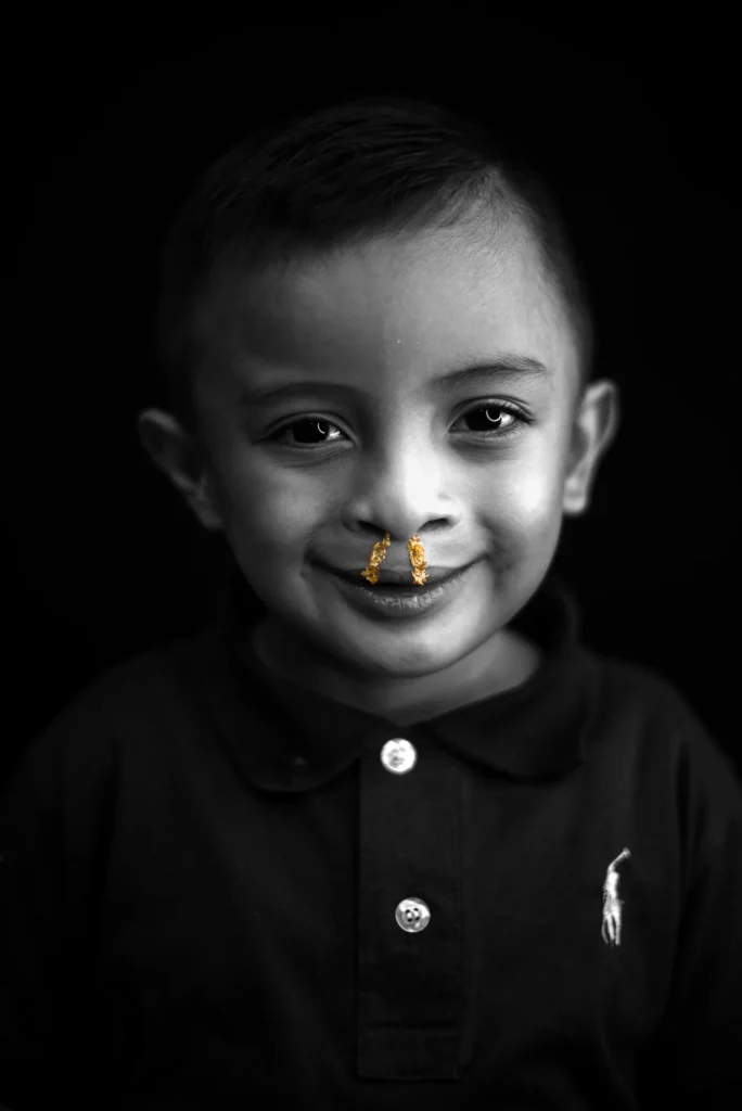 A boy in a polo shirt looks straight at the camera