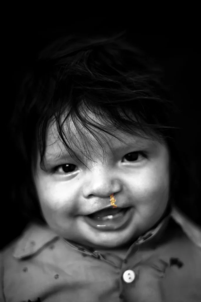 A baby smiles at the camera