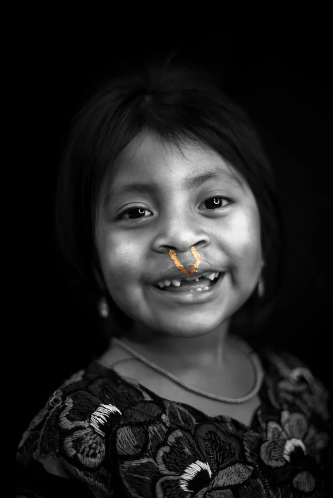 A girl in an embroidered blouse, smiling wide