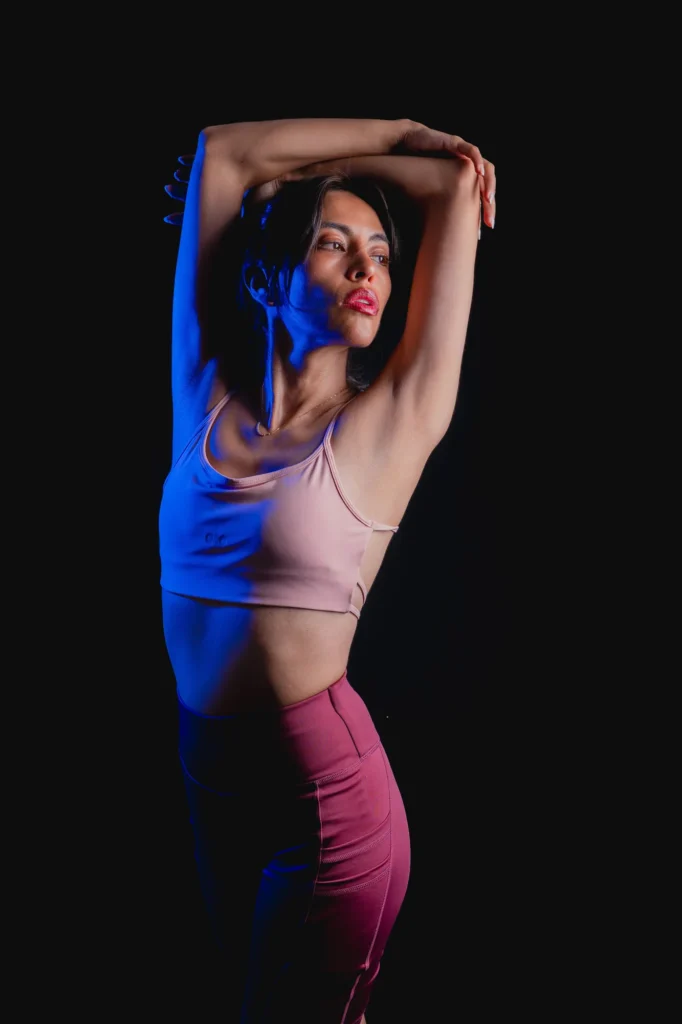 Arms overhead in pink and blue light