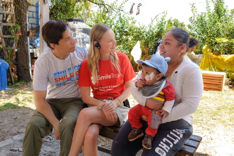 Kate and Justin with a mother and her baby in their backyard