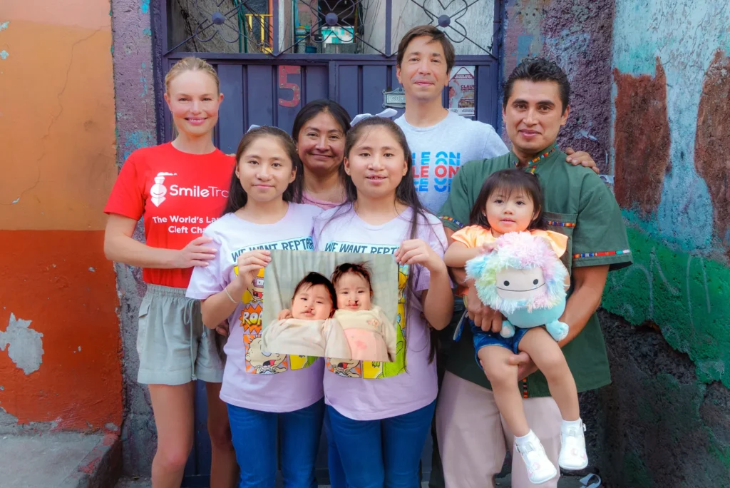 In the alley, a family holds up their baby's portrait