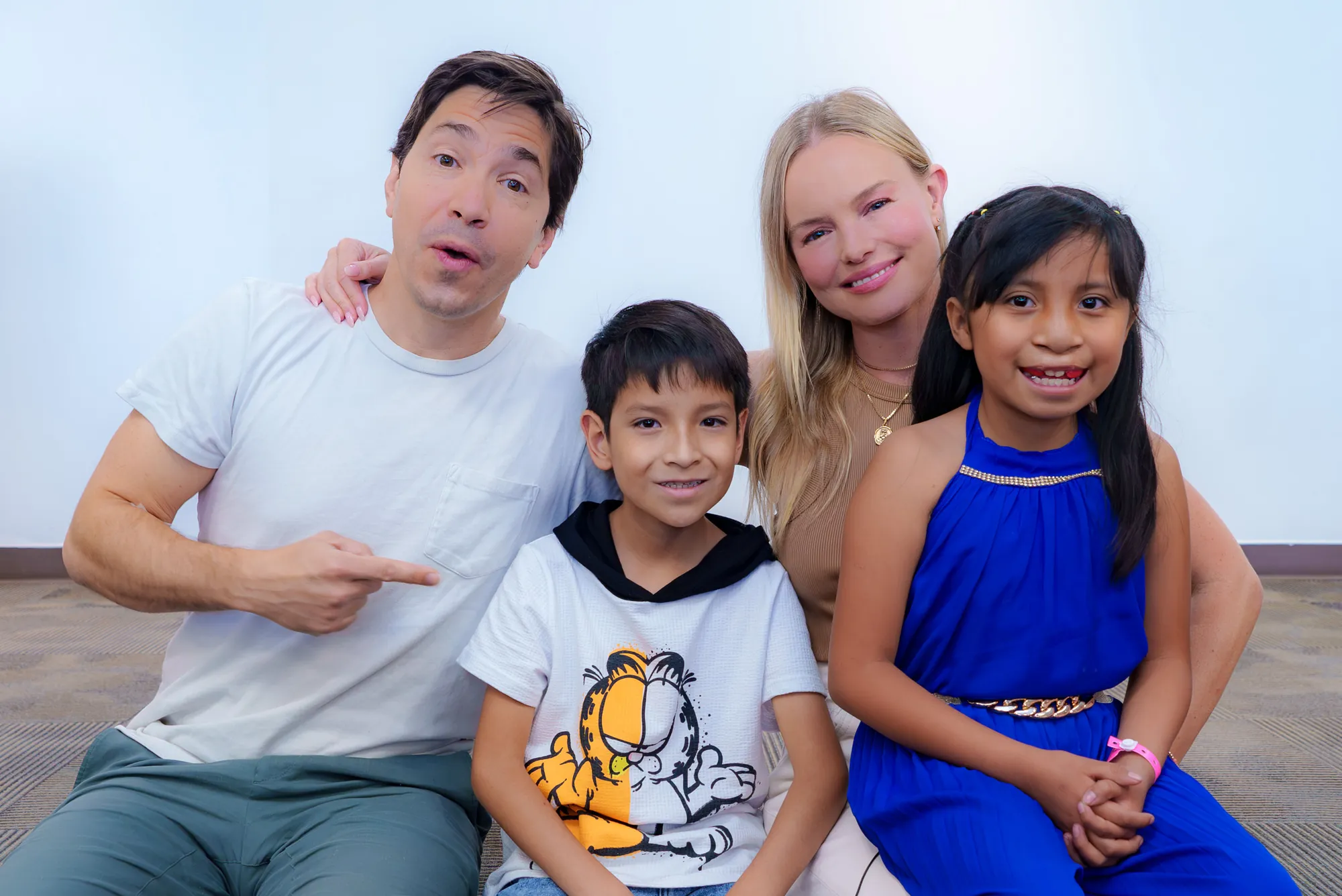 Justin and Kate kneel beside two children