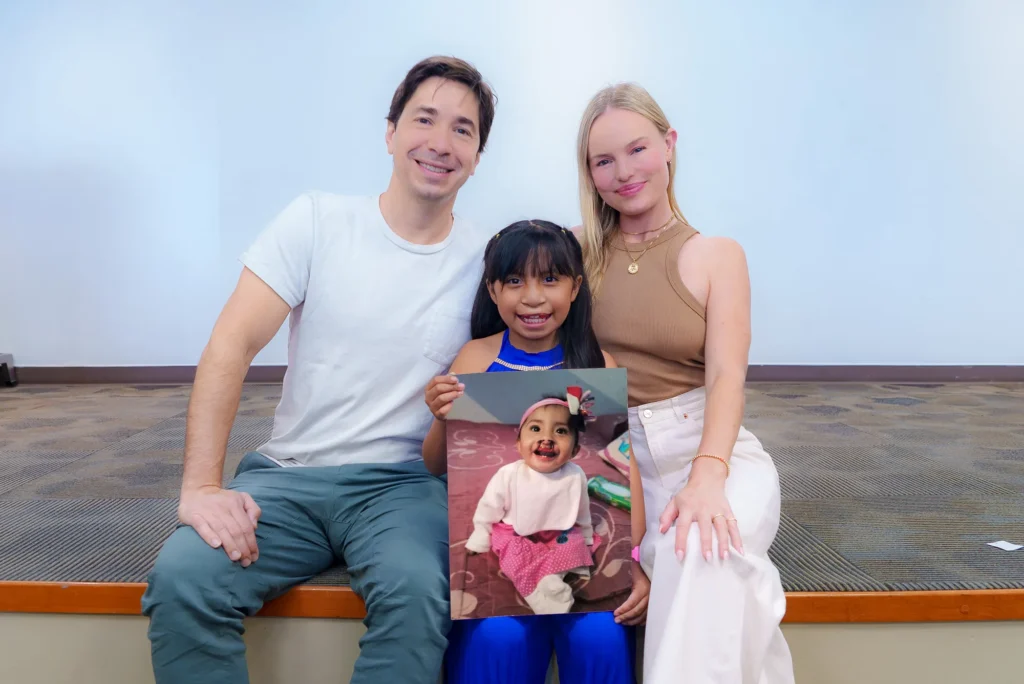 A girl shows her baby photo to Justin and Kate