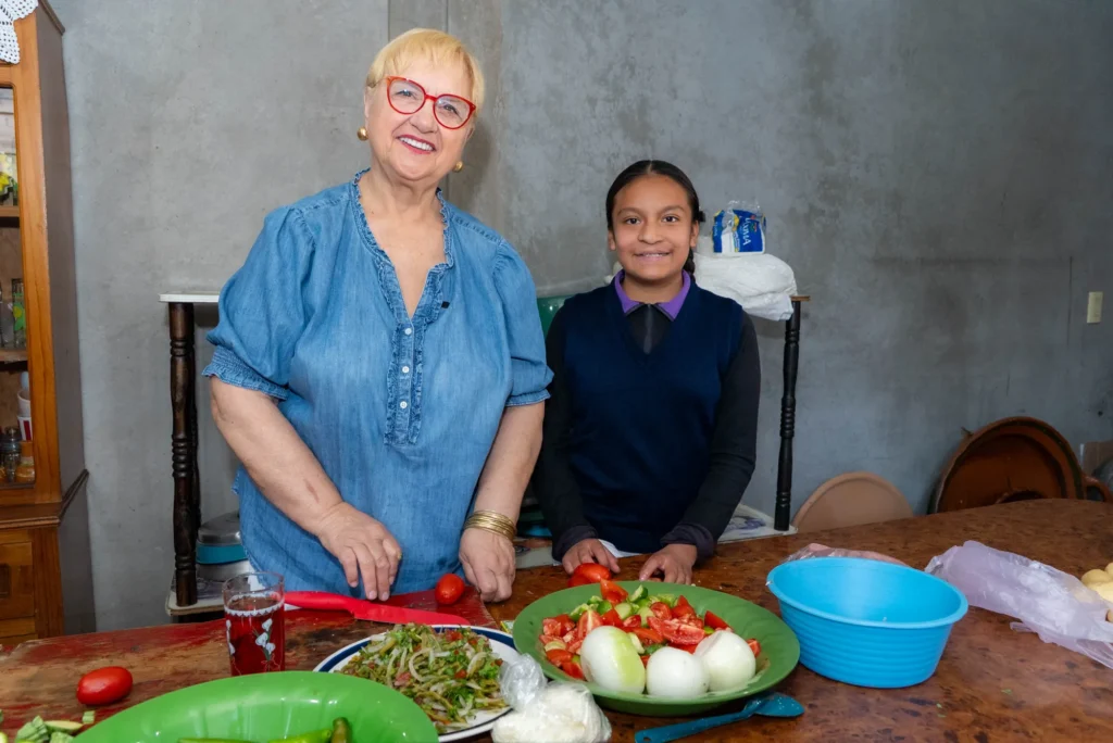 Lidia cooks with a young woman in her family's home