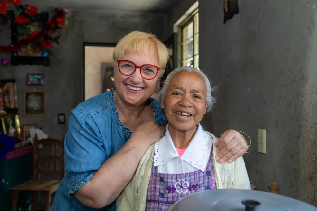 Lidia hugs a grandmother in her kitchen