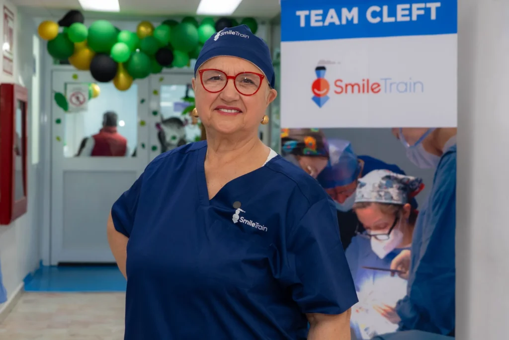 Lidia in scrubs by the Team Cleft sign