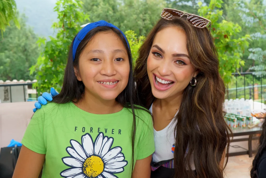 A girl in a daisy shirt next to a titleholder