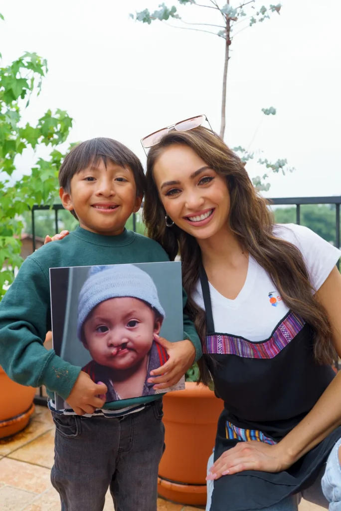 A boy holds his baby photo next to a titleholder