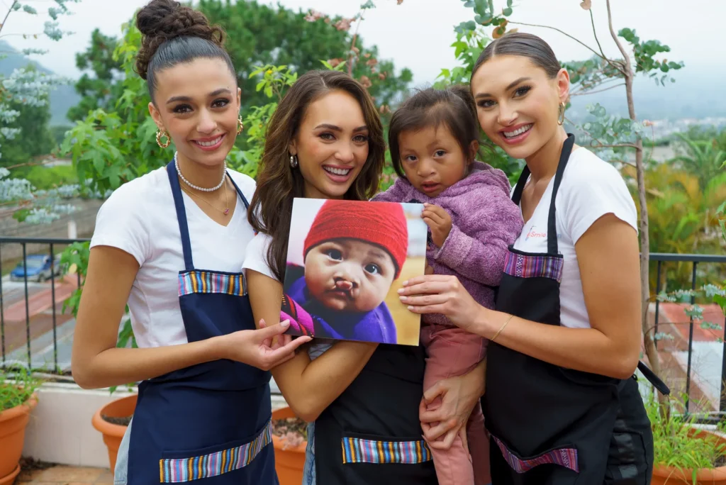 The girls hold up a baby photo