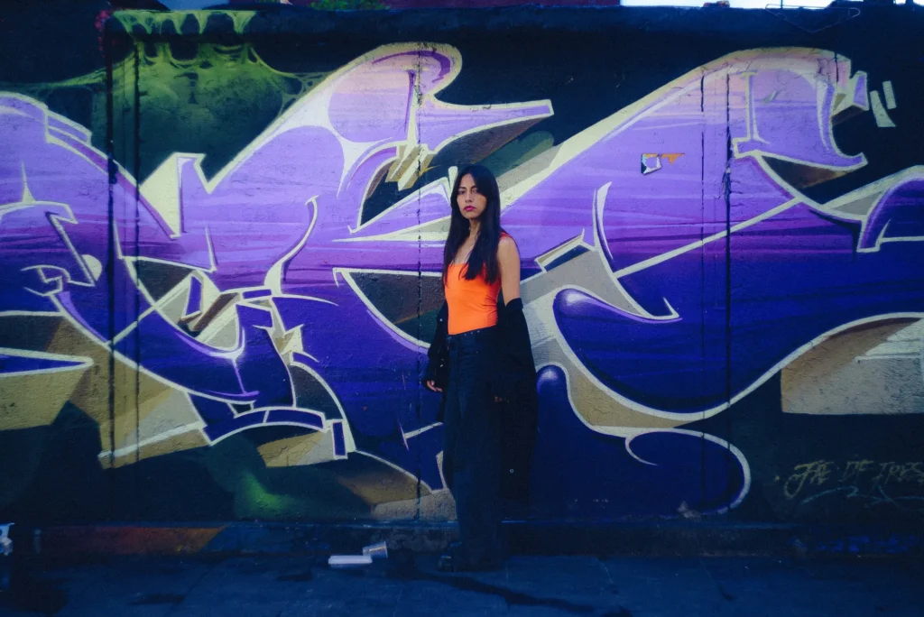 Before a purple graffiti wall