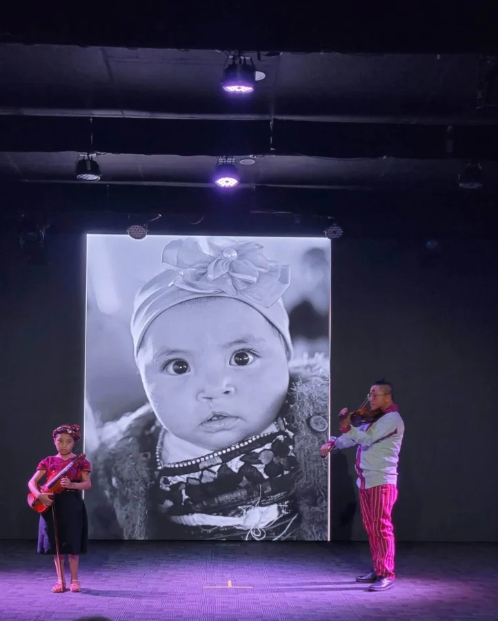 A Kintsugi portrait on screen, with live music