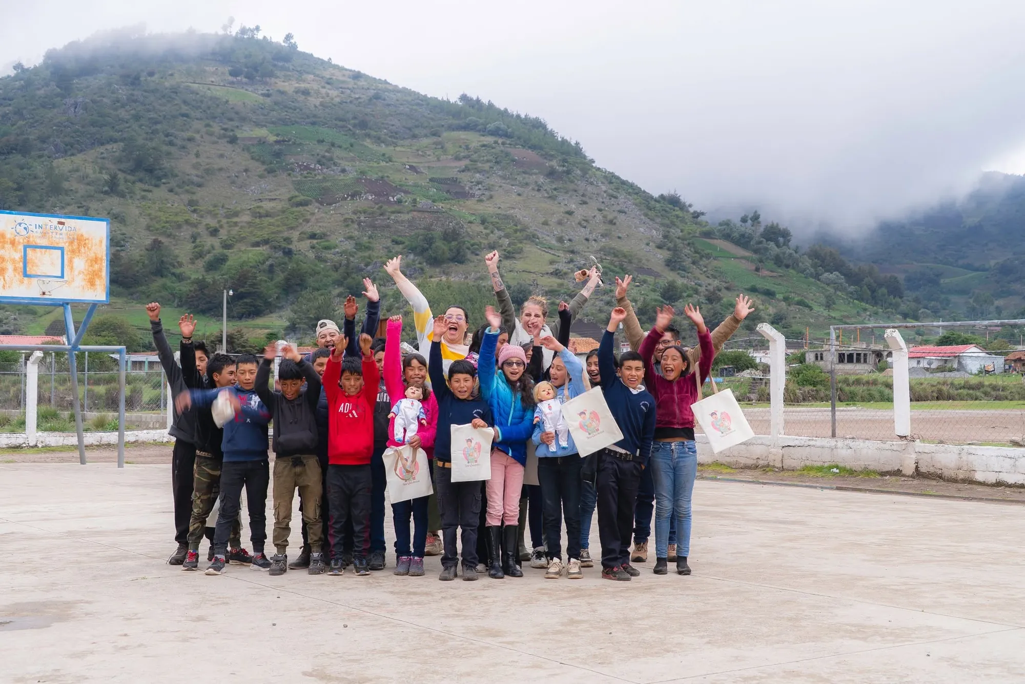 Jennifer, arms up with her classmates in the schoolyard